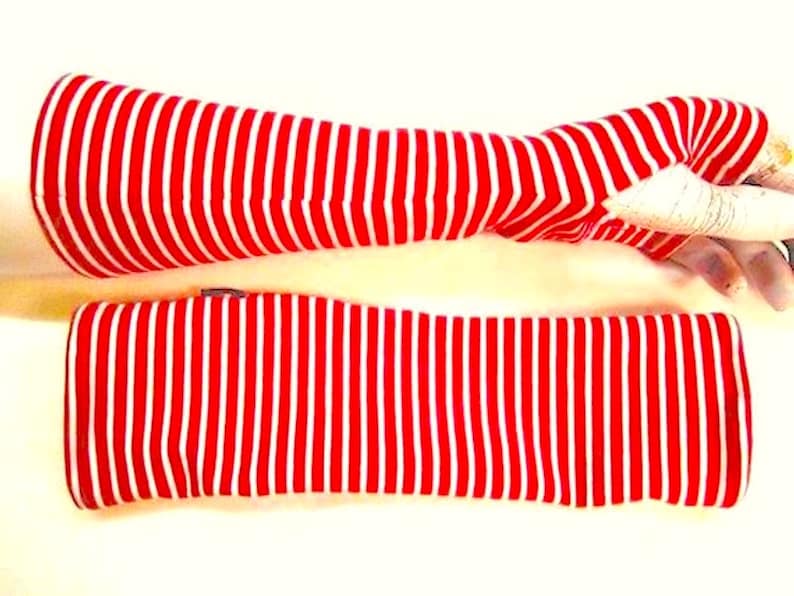 May include: A pair of red and white striped arm warmers. The arm warmers are made of a soft, stretchy fabric and are perfect for keeping your arms warm in the cooler months.