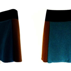 May include: A three-toned skirt with a black waistband, a brown side panel, and a teal blue side panel.