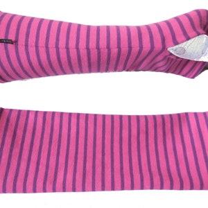 May include: Pink and purple striped arm warmers. The arm warmers are made of a soft, stretchy fabric and feature a repeating pattern of vertical stripes. The arm warmers are shown in two views, one on a mannequin arm and one flat.