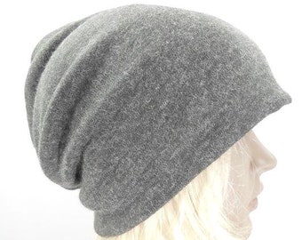 May include: A grey slouchy beanie hat made of soft, fuzzy fabric. The hat is worn on a person's head, with the brim pulled down over their forehead.
