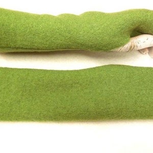 May include: A pair of green fingerless gloves made of a soft, fuzzy material. The gloves are shown folded in half, with one glove on a hand model.