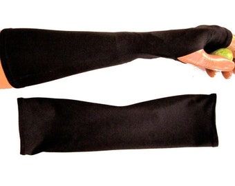 May include: A pair of black arm warmers made of a soft, stretchy fabric. The arm warmers are shown laid flat on a white surface.
