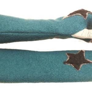 Puede incluir: Un par de guantes sin dedos de color azul turquesa con un detalle de estrella marrón. Los guantes están hechos de un material suave y peludo.