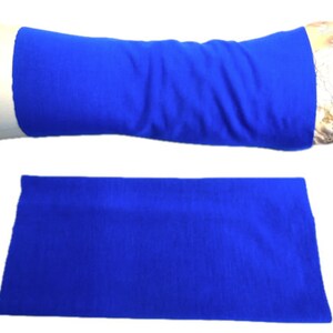 Puede incluir: Un calienta brazos de tela azul, mostrado plano y en el brazo de un maniquí. El calienta brazos está hecho de un material suave y elástico.