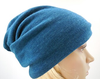 May include: A teal blue slouchy beanie hat made of soft knit fabric.