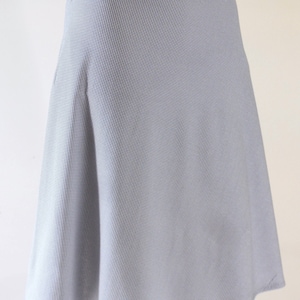 May include: A knee-length skirt featuring a fine black and white gingham check pattern. The garment has a fitted waistband and a slightly flared A-line silhouette that hangs straight down from the waist, providing a clean and simple look.