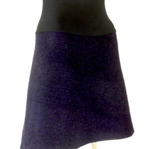 May include: A dark purple skirt with a black waistband. The skirt is made of a soft, textured fabric.