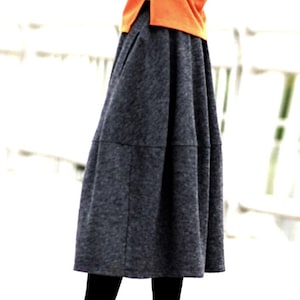 Op de afbeelding: Een grijze midi-rok met een geplooide look. De rok heeft een licht uitlopende pasvorm en is gemaakt van een zachte, comfortabele stof.