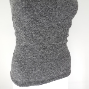May include: A gray, fuzzy, strapless top made of a soft, textured fabric. The top is fitted and has a simple, classic design.