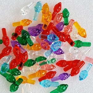 Puede incluir: Surtido de cubiertas de bombillas de luces navideñas de plástico de colores en varias formas y tamaños. Las cubiertas son en tonos rojo, verde, azul, naranja, morado y transparente.