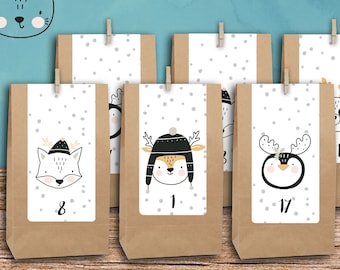 Op de afbeelding: Een set van 24 bruine papieren zakjes, 24 stickers en 24 houten knijpers voor een adventskalender. Elk zakje heeft een wit label met een grijs stippenpatroon en een cartoonillustratie van een dier, zoals een vos, hert, pinguïn en wasbeer.
