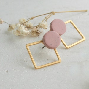 Puede incluir: Un par de pendientes de botón cuadrados de oro con tapas redondas de cerámica rosa.