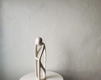 Estatua de esteatita de Kisii, Kenia. Escultura tribal abstracta de un hombre pensante tallada a mano en color blanco roto.