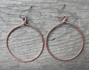Large hammered copper hoop earrings on antiqued copper earwires