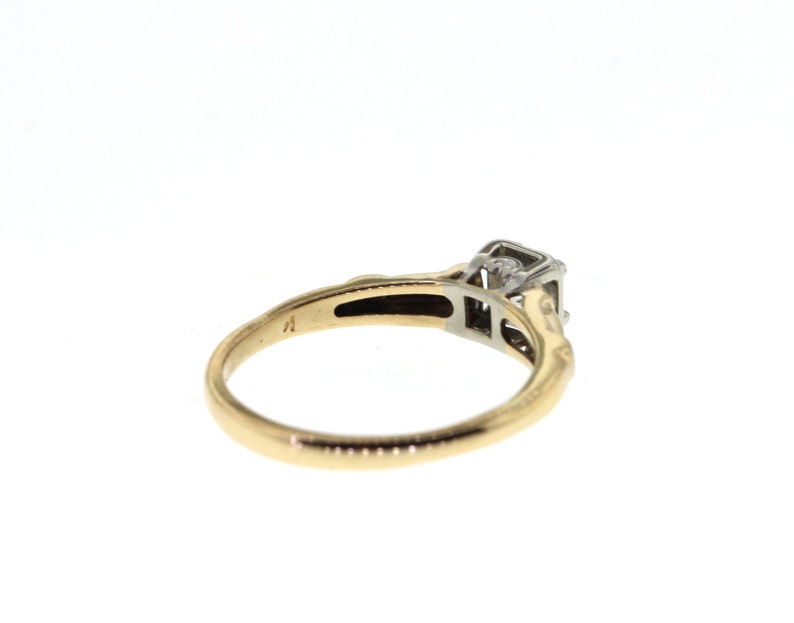 May include: A gold and silver engagement ring with a single diamond set in a square shape.