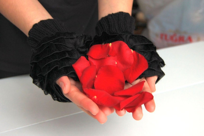 Pode incluir: Um par de luvas sem dedos de renda preta com p&eacute;talas de rosa vermelha na palma da m&atilde;o.