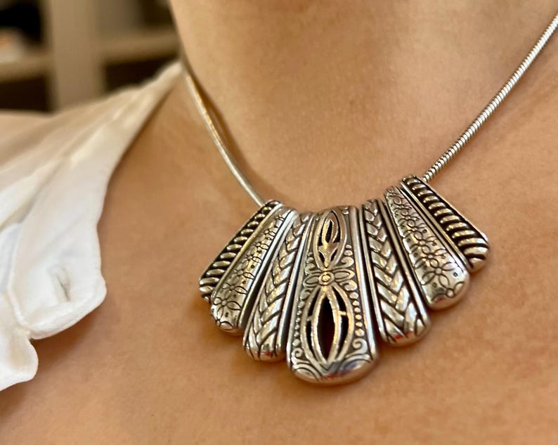 Puede incluir: Una taza de cer&aacute;mica blanca con un asa negra y el texto "But First, Coffee" en negro, con una fuente de estilo manuscrito. La taza est&aacute; sobre una superficie blanca.