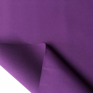 May include: A close-up of a purple fabric folded over on itself. The fabric has a smooth, even texture.