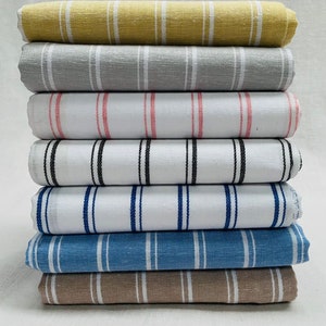 Pu&ograve; includere: Un mucchio di otto campioni di tessuto a righe in vari colori, tra cui beige, grigio, bianco, rosa, nero, blu e marrone.