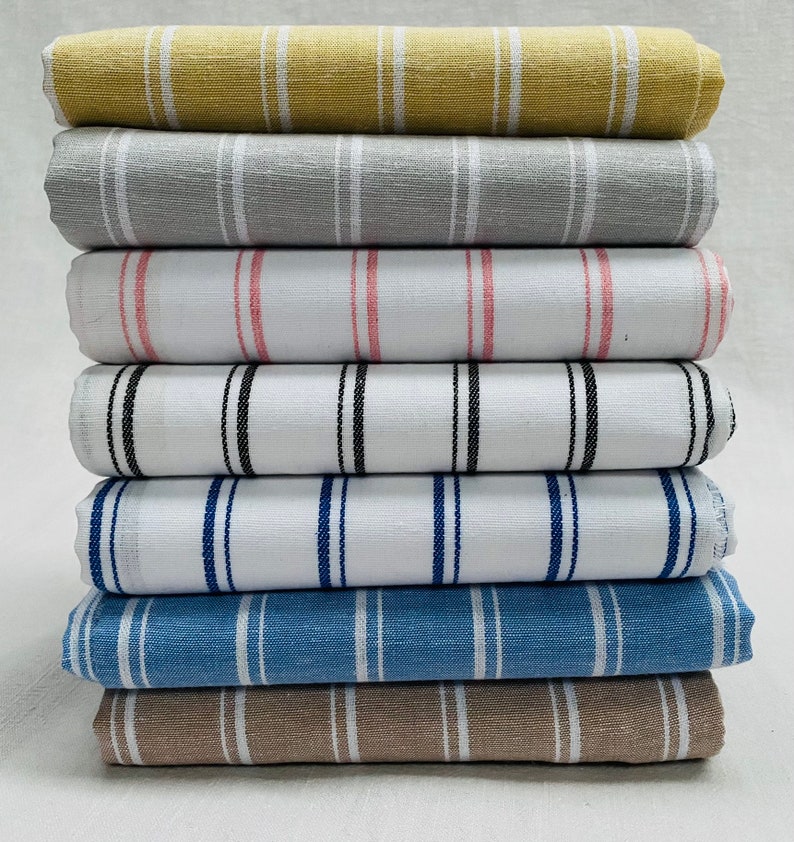 Pu&ograve; includere: Un mucchio di otto campioni di tessuto a righe in vari colori, tra cui beige, grigio, bianco, rosa, nero, blu e marrone.