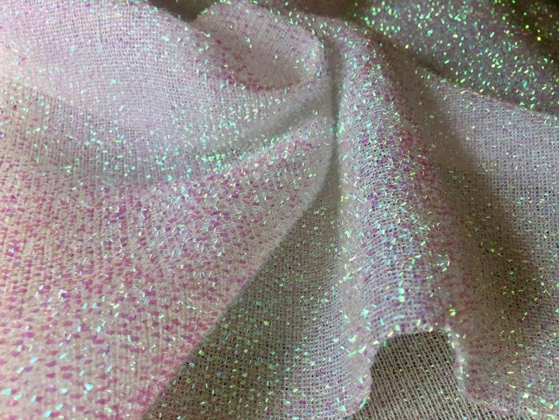 May include: White iridescent mesh fabric with a subtle sparkle. The fabric has a woven texture and is slightly translucent.