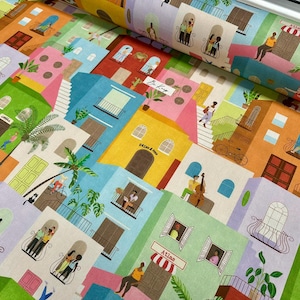 Peut inclure: Un rouleau de tissu présentant un motif répétitif et coloré de bâtiments à plusieurs étages dans des tons jaune, bleu, vert, rose et orange. Le design inclut des illustrations de personnes sur des balcons, des palmiers et des boutiques Atlas.