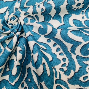 May include: Teal and white fabric with a large-scale, abstract floral pattern. The fabric has a textured, woven look.