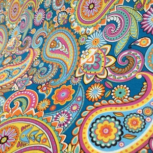 May include: A colorful paisley pattern fabric with a blue background. The pattern features a variety of colors, including pink, yellow, orange, and green. The fabric is perfect for crafting projects, such as making clothing, accessories, or home decor.