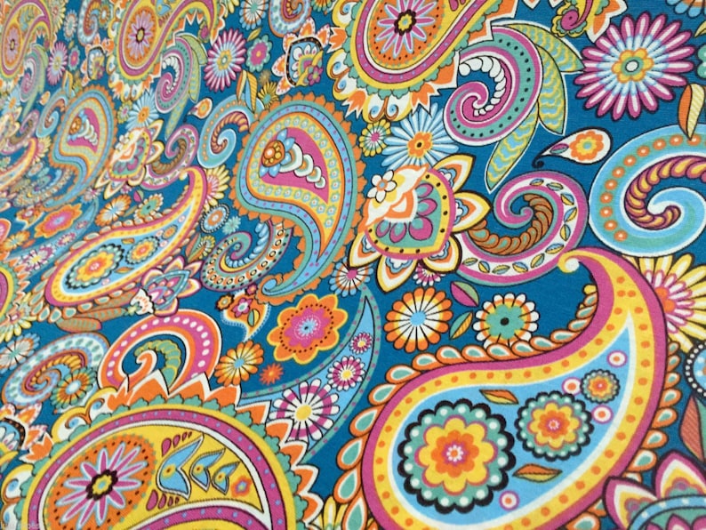 May include: A colorful paisley pattern fabric with a blue background. The pattern features a variety of colors, including pink, yellow, orange, and green. The fabric is perfect for crafting projects, such as making clothing, accessories, or home decor.