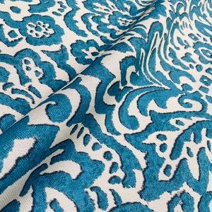 May include: Teal and white fabric with a damask pattern. The fabric has a textured surface and a subtle sheen.