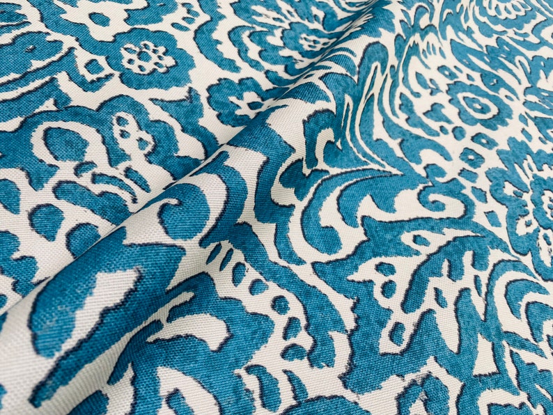 May include: Teal and white fabric with a damask pattern. The fabric has a textured surface and a subtle sheen.