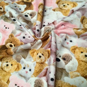 May include: A pink and white fabric with a repeating pattern of teddy bears and other stuffed animals. The fabric is soft and cuddly, perfect for making blankets, pillows, or other crafts.