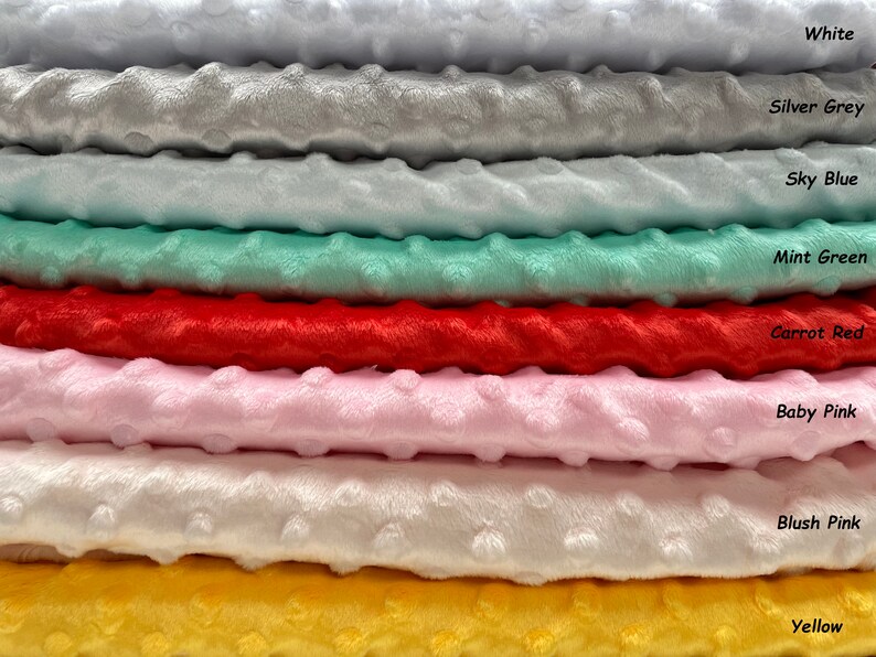 May include: A stack of eight different colors of soft, plush fabric. The colors are white, silver grey, sky blue, mint green, carrot red, baby pink, blush pink, and yellow.