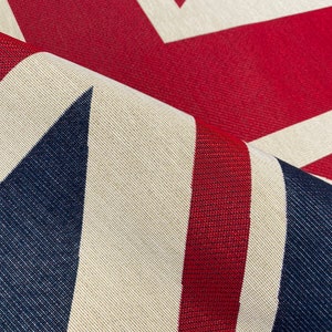 May include: Close-up of a fabric with a Union Jack pattern. The fabric is red, white, and blue and has a textured weave.
