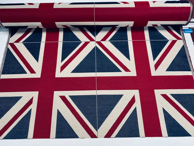 May include: A close-up of fabric with a repeating pattern of the Union Jack flag. The fabric is a cream color with red and navy blue accents.