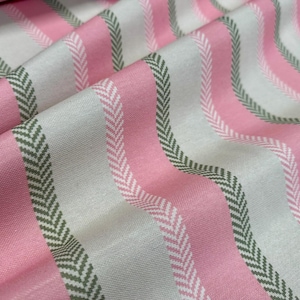 Könnte beinhalten: Nahaufnahme eines Stoffes mit einem sich wiederholenden Muster aus wellenförmigen Streifen. Die Streifen wechseln sich zwischen Rosa, Off-White und einem dunkelgrünen Fischgrätmuster ab. Der Stoff ist gefaltet und erzeugt Schatten und Textur.