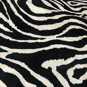 Puede incluir: Tela de estampado de cebra en blanco y negro con un patrón ondulado.