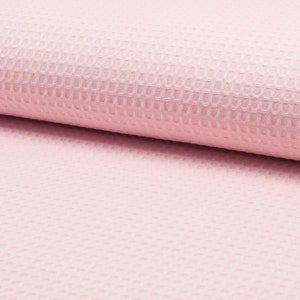 May include: Pink waffle knit fabric. The fabric has a textured waffle pattern and is soft to the touch.