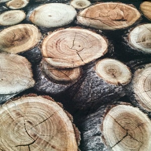 Peut inclure: Gros plan sur un tissu à motif bois. Le tissu présente un motif répétitif d'anneaux d'arbres bruns et beiges, ressemblant à une pile de bûches.