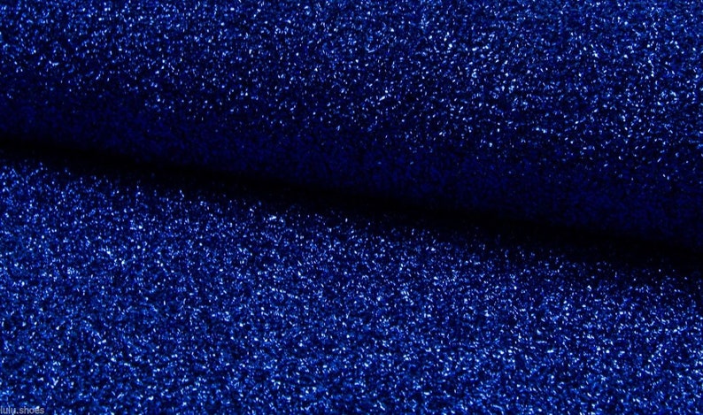 May include: A close-up of a blue fabric with a sparkly, glittery texture.