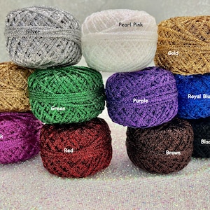 Può includere: Dieci rocchetti di filo scintillante in vari colori, tra cui argento, oro, verde, viola, blu reale, nero, rosa, rosso, marrone e rosa perlato. Ogni rocchetto è etichettato con il suo colore.