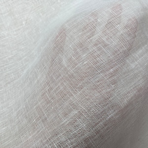 May include: White sheer fabric with a woven texture. The fabric is lightweight and translucent.