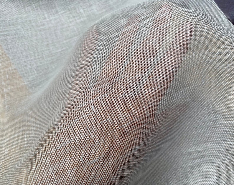 Puede incluir: Tela blanca transparente con una textura fina y tejida. La tela es suave y delicada, con una apariencia ligeramente transl&uacute;cida.