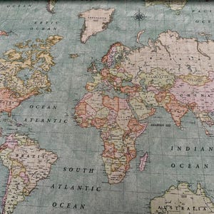 Può includere: Una mappa del mondo dettagliata con un'estetica vintage. La mappa presenta i continenti in colori tenui, con gli oceani in una tonalità azzurra. La mappa include etichette per oceani e paesi, e una rosa dei venti.