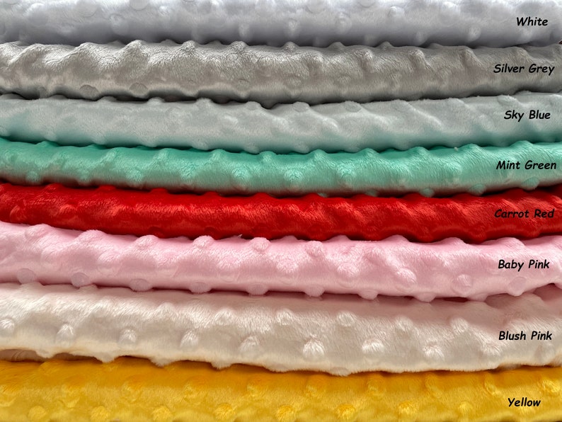 May include: A stack of eight different colors of soft, plush fabric. The colors are white, silver grey, sky blue, mint green, carrot red, baby pink, blush pink, and yellow.