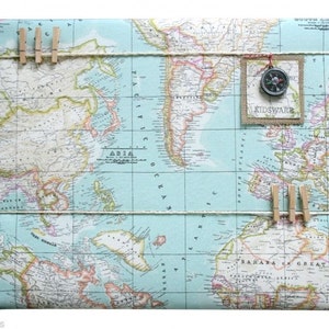 May include: A light blue world map wrapping paper with a compass and the text "KIDSWARE" on a burlap tag. The map is decorated with twine and wooden clothespins.