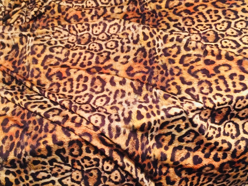K&ouml;nnte beinhalten: Nahaufnahme eines Stoffes mit braunem und orangefarbenem Leopardenmuster.