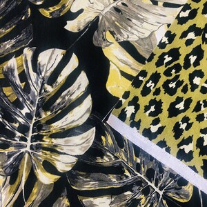May include: Two fabric swatches, one with a black and white tropical leaf pattern and the other with a black and yellow leopard print.