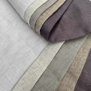 Puede incluir: Una colecci&oacute;n de muestras de tela en varios tonos de gris, beige y marr&oacute;n. Las muestras est&aacute;n hechas de un material texturizado similar al lino.