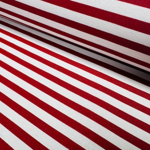 May include: Red and white striped fabric. The fabric is folded in half, showing the stripes running diagonally.